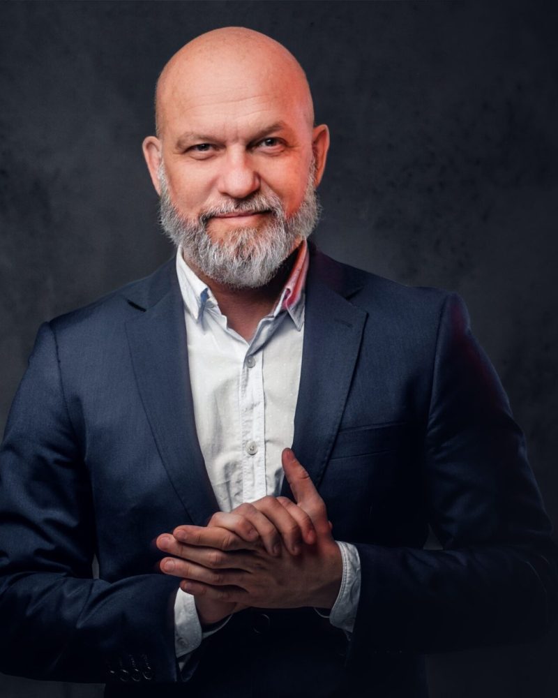 portrait-bald-senior-dressed-stylish-suit-posing-against-dark-background (1)